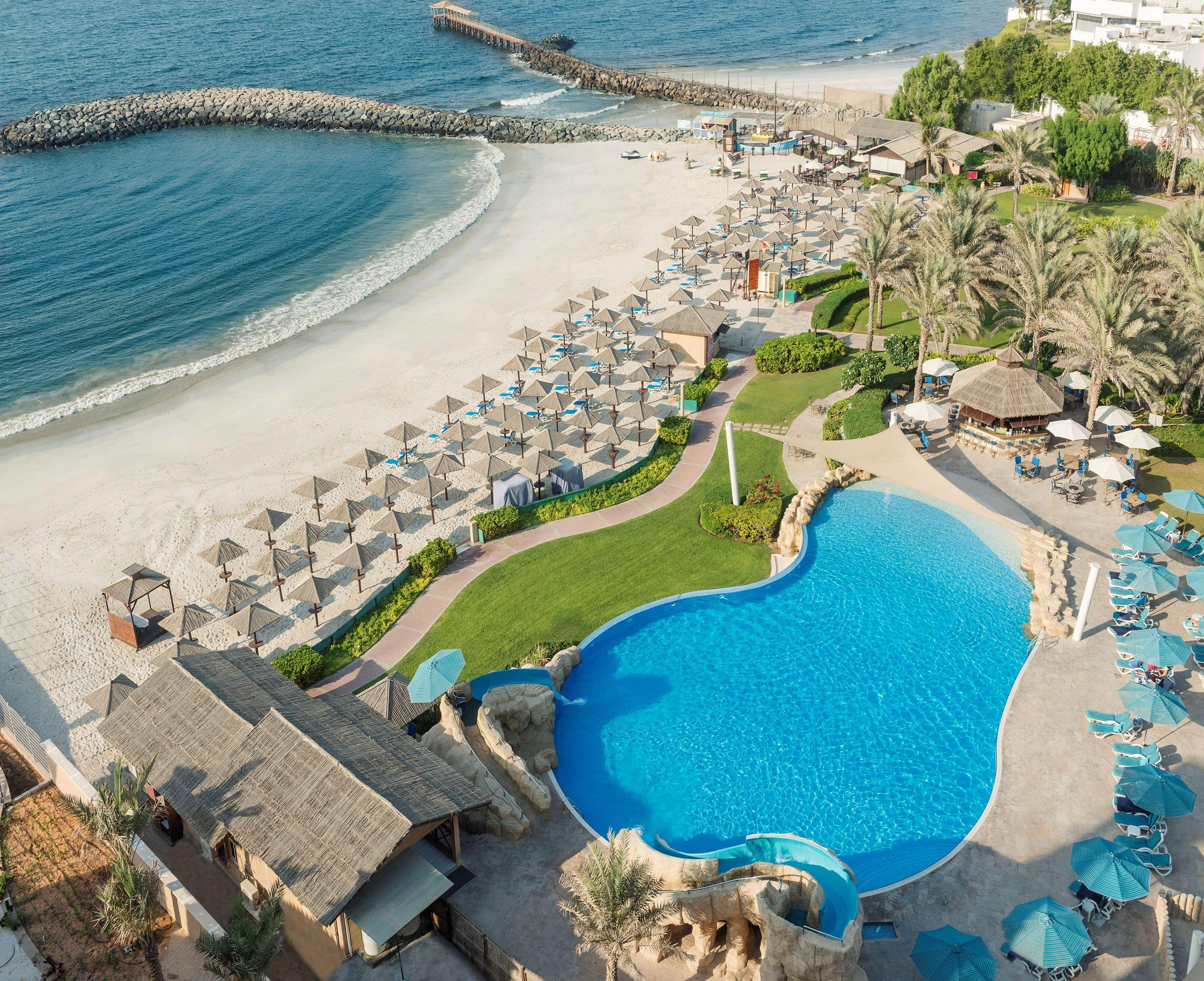 래디슨 블루 호텔, 아즈만 아지만 외부 사진 Aerial view of the beach and pool at the resort